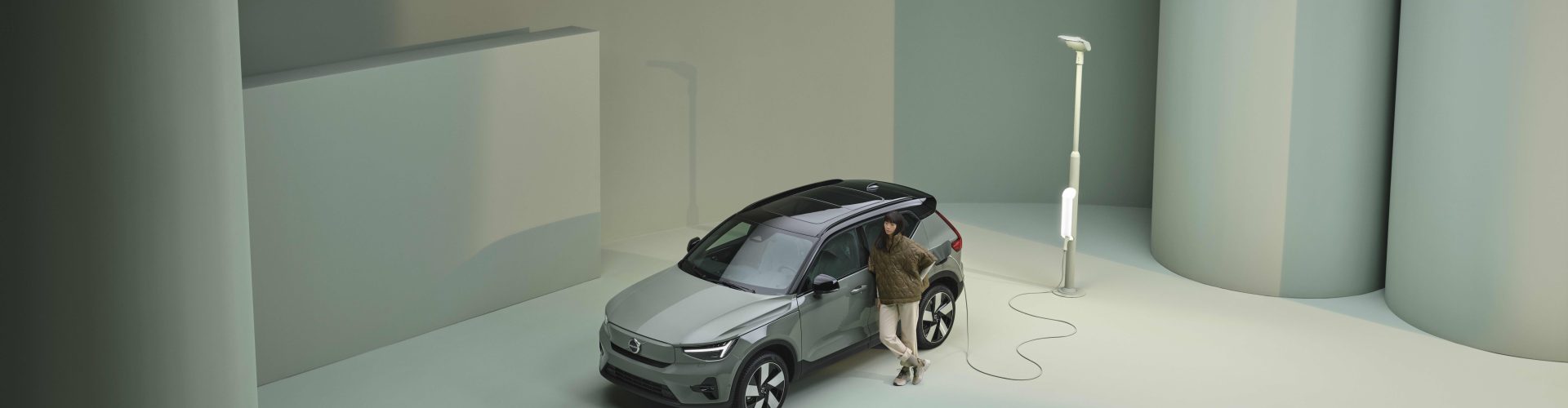 Grön Volvo EX40 vid laddstolpe