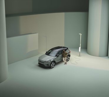 Grön Volvo EX40 vid laddstolpe
